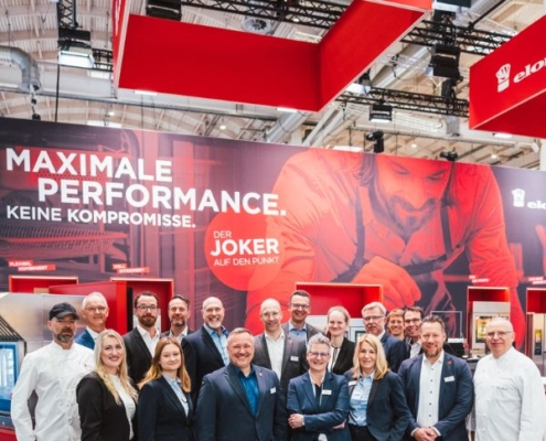 Hier im Bild sehen wir auf der Hamburger Leitmesse für Gastronomie 2025 die Standmannschaft vom Hersteller für Kombidämpfer Eloma. Eloma ist eine Marke der Ali Group und stellt hochwertige Öfen in Deutschland her.