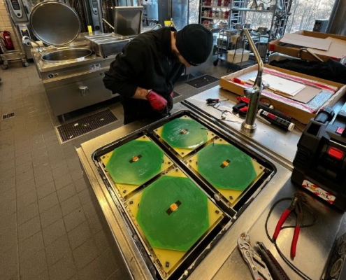 Reparatur durch Servicetechniker in der Gastroküche an einem Gastroherd...