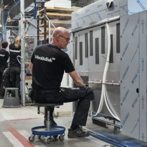 Im Bild sieht man Einblicke in die Fabrik Wexiödisk aus Schweden. Hier im Vordergrund sieht man einen Produktionsmitarbeiter bei der Fertigung einer Korbtransportmaschine. Wexiödisk ist ein Tochterunternehmen der Ali Group.